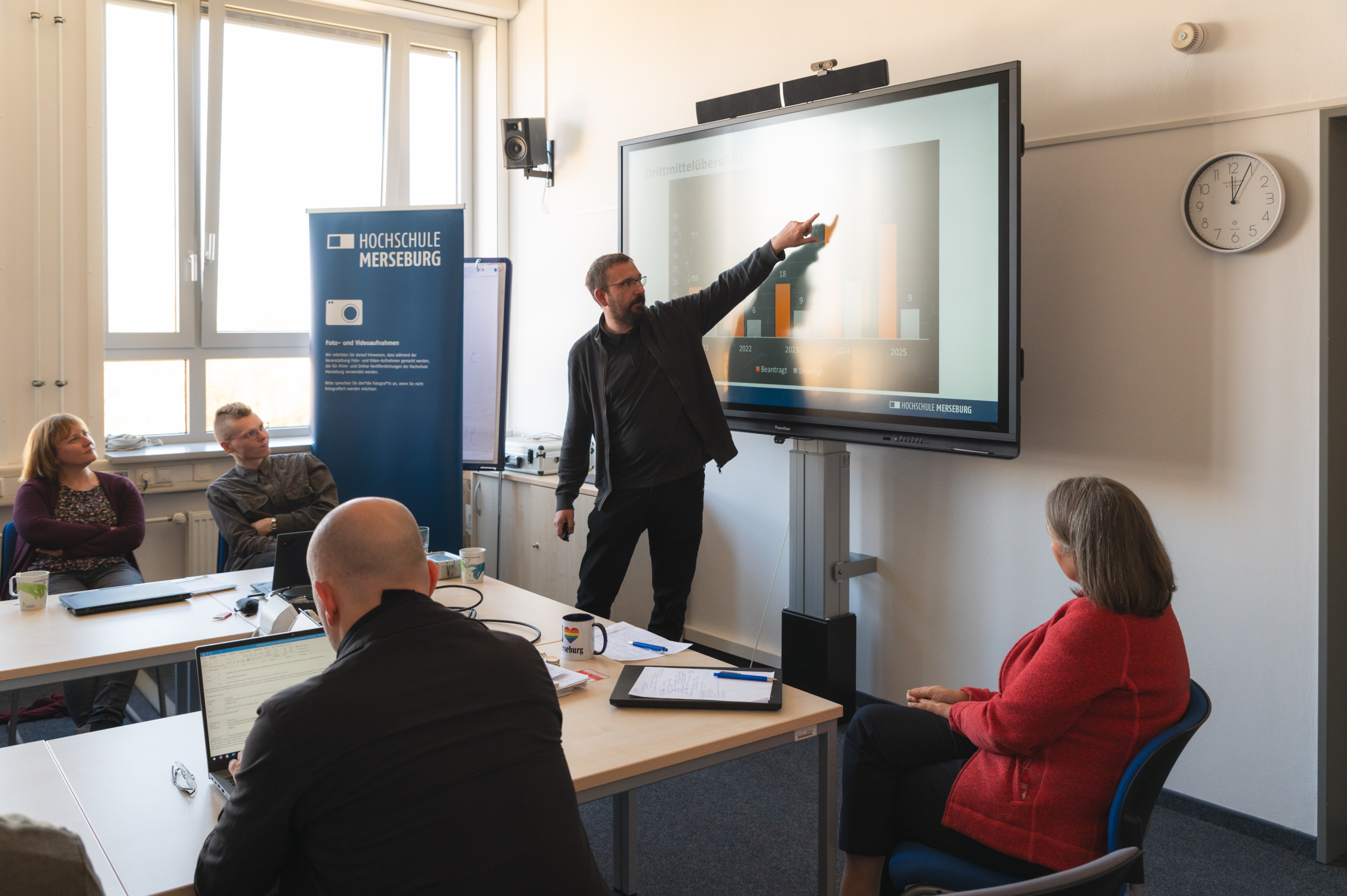 Mitarbeiter referiert zu einem Thema und untermauert seine Gedanken mit Hilfe einer Präsentation.