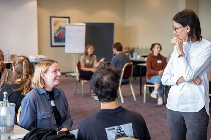 Das Bild zeigt einige Personen, die sich unterhalten.