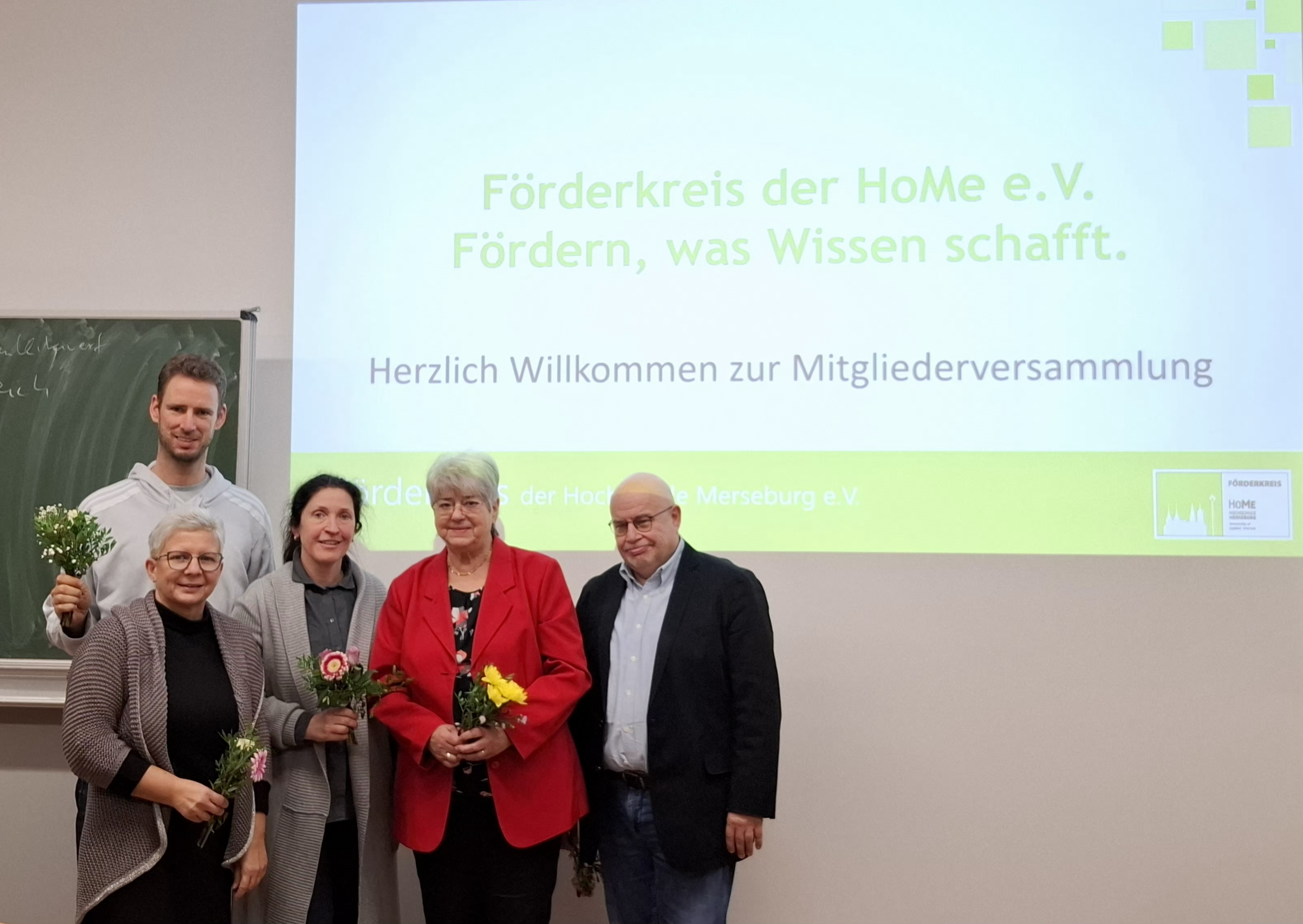 5 Personen klein, im Hintergrund Präsentation