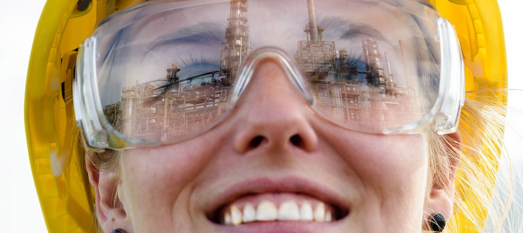 Frau mit gelbem gelbem Helm lächelt mit dem Blick nach oben