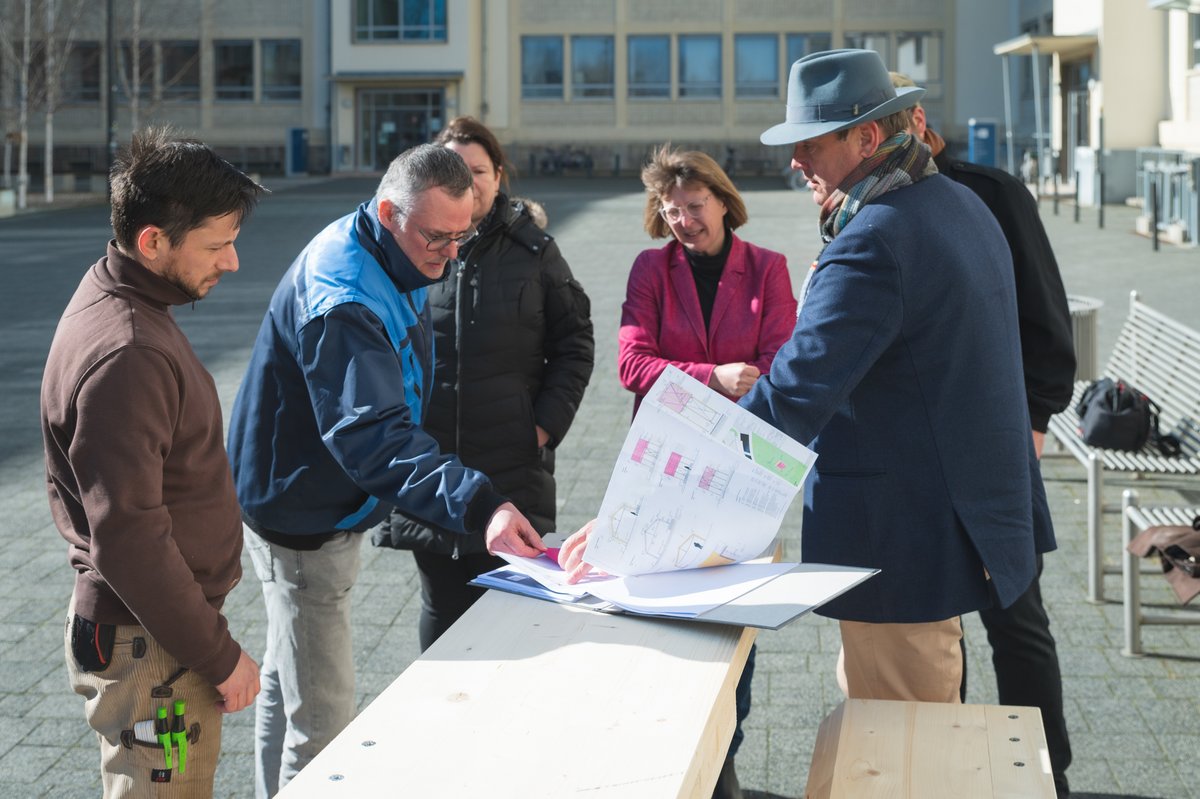 Eine Gruppe von Menschen bespricht einen Bauplan.