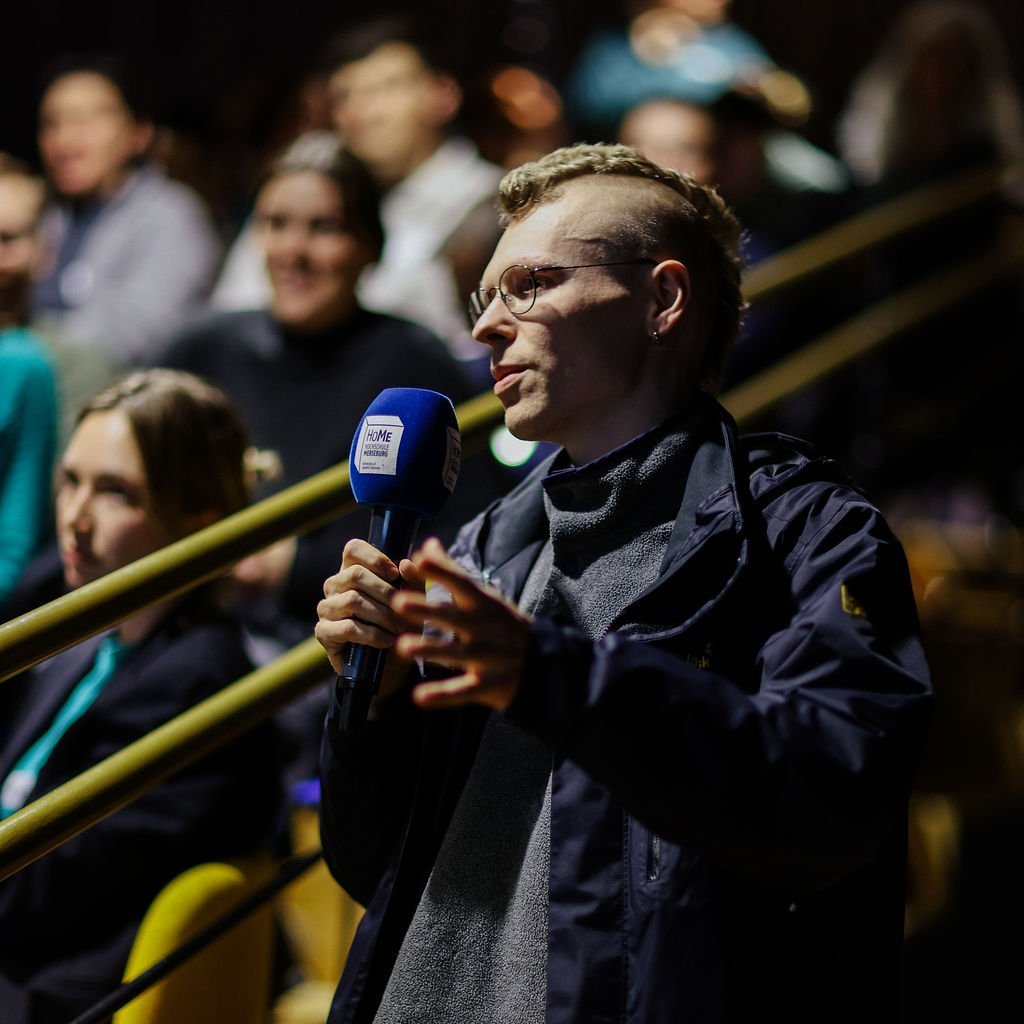 Eine Person die eine Frage stellt.