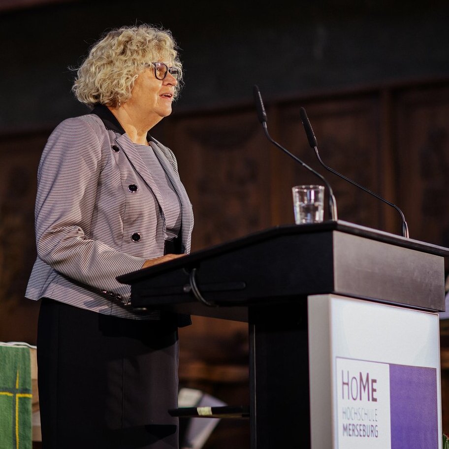 Person am Rednerpult von der Seite