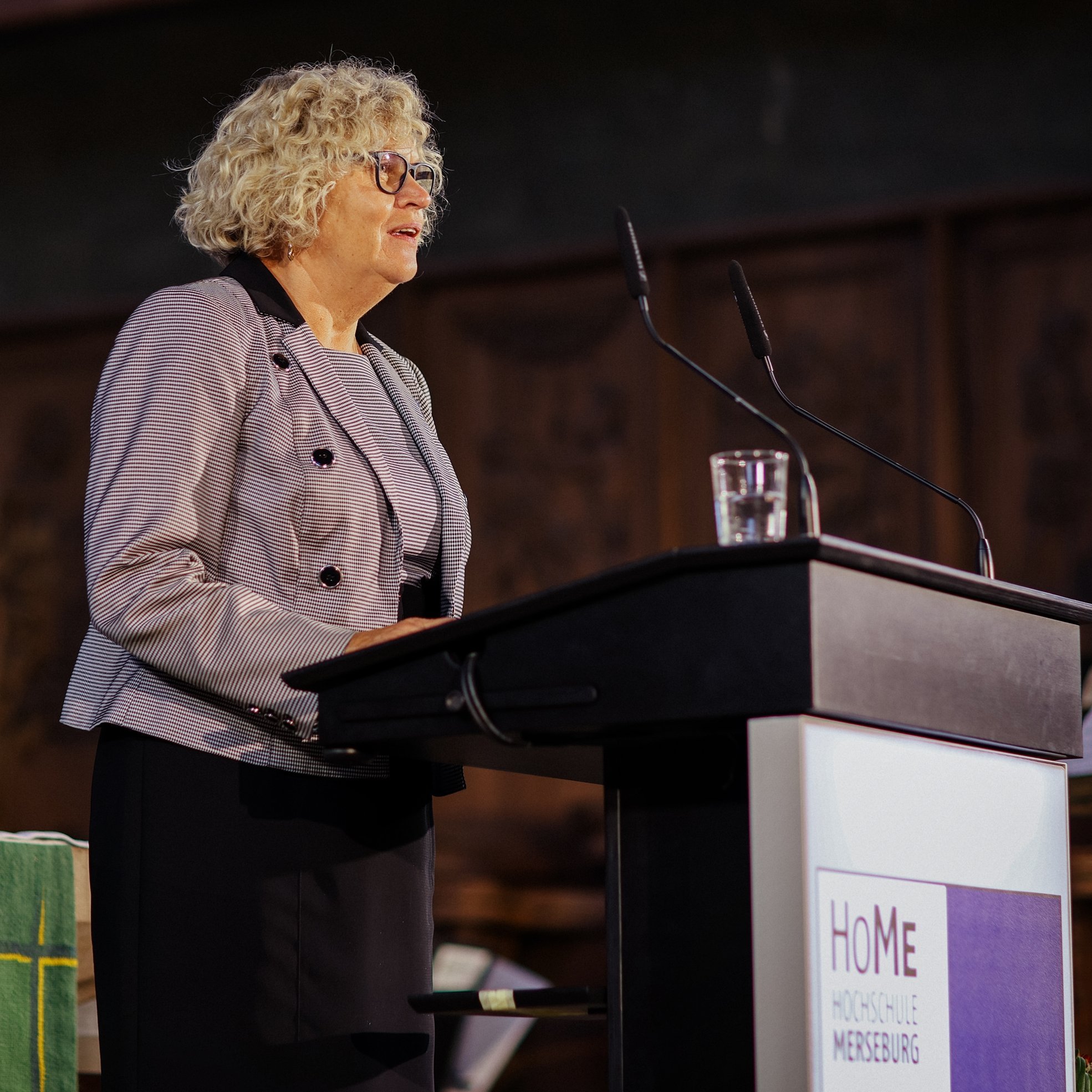 Person am Rednerpult von der Seite