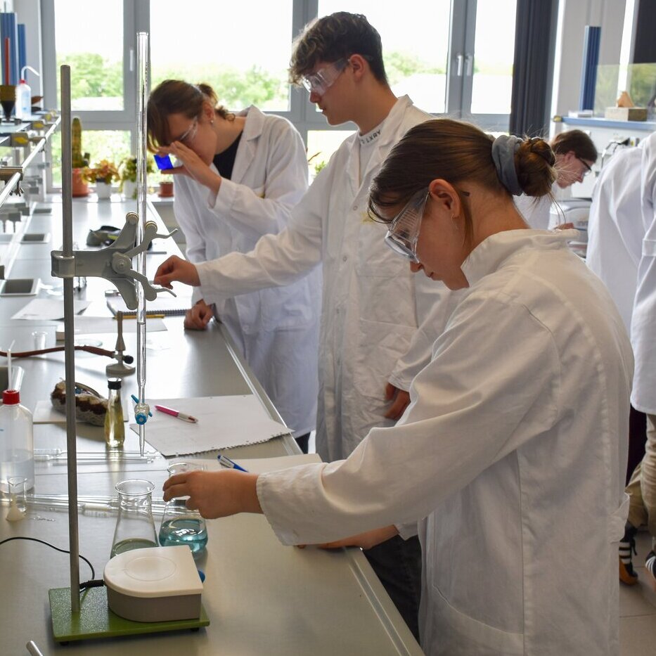 Einblick in die praktische Übung im Rahmen des Wettbewerbs "Chemie - die stimmt!"" Wettbewerb "Chemie - die stimmt!" Personen experimentieren im Labor
