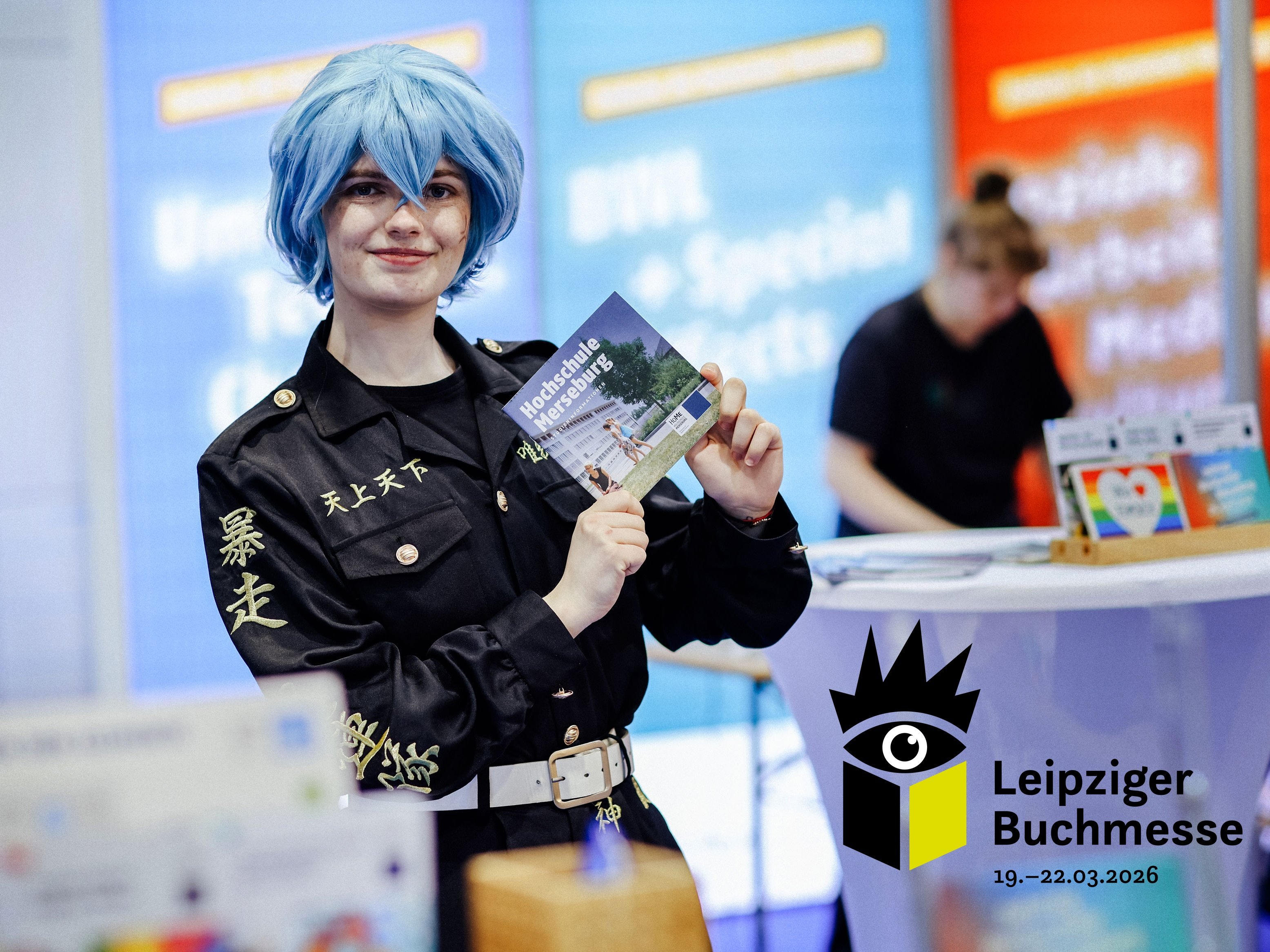 Buchmesse Leipzig Person hält Flyer hoch