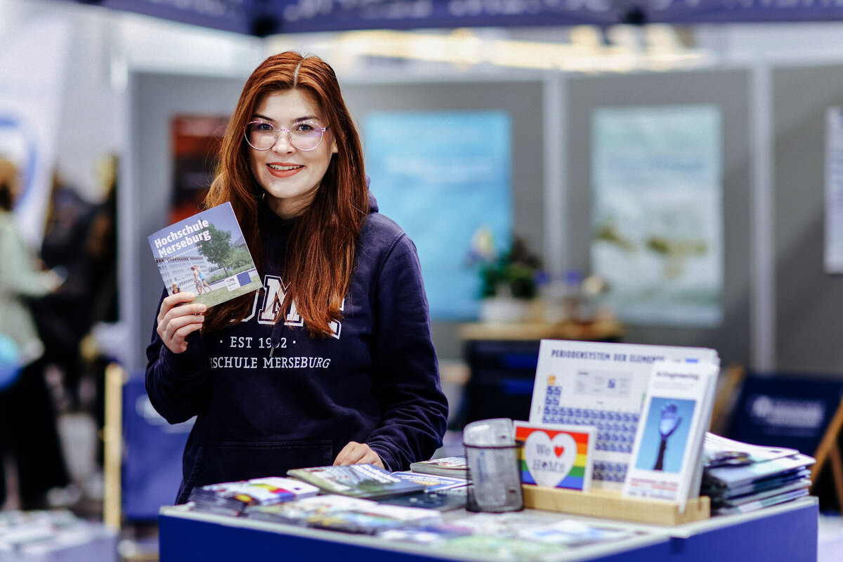 Eine Studentin steht vor einem Messestand