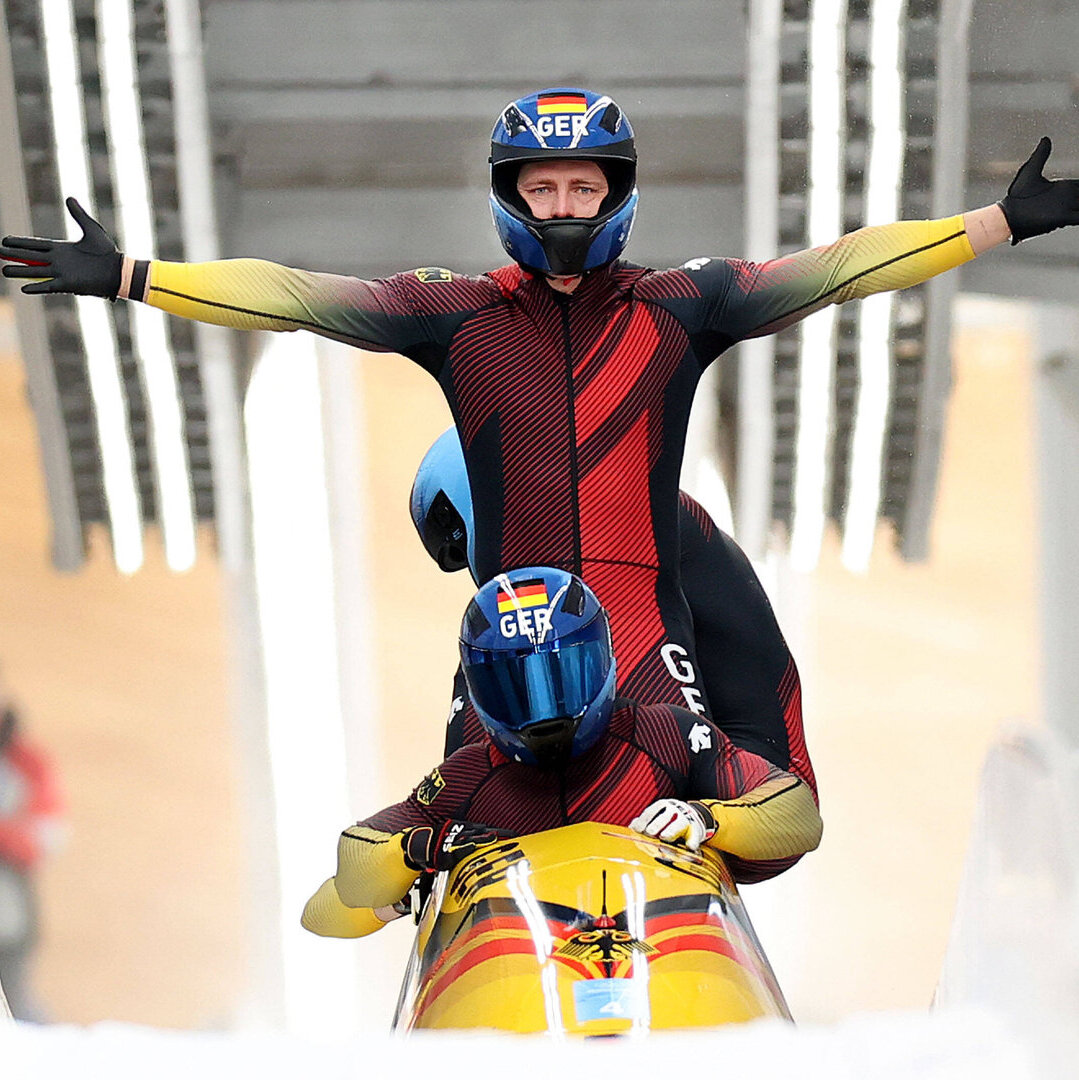 Mann jubelt stehend im Bob