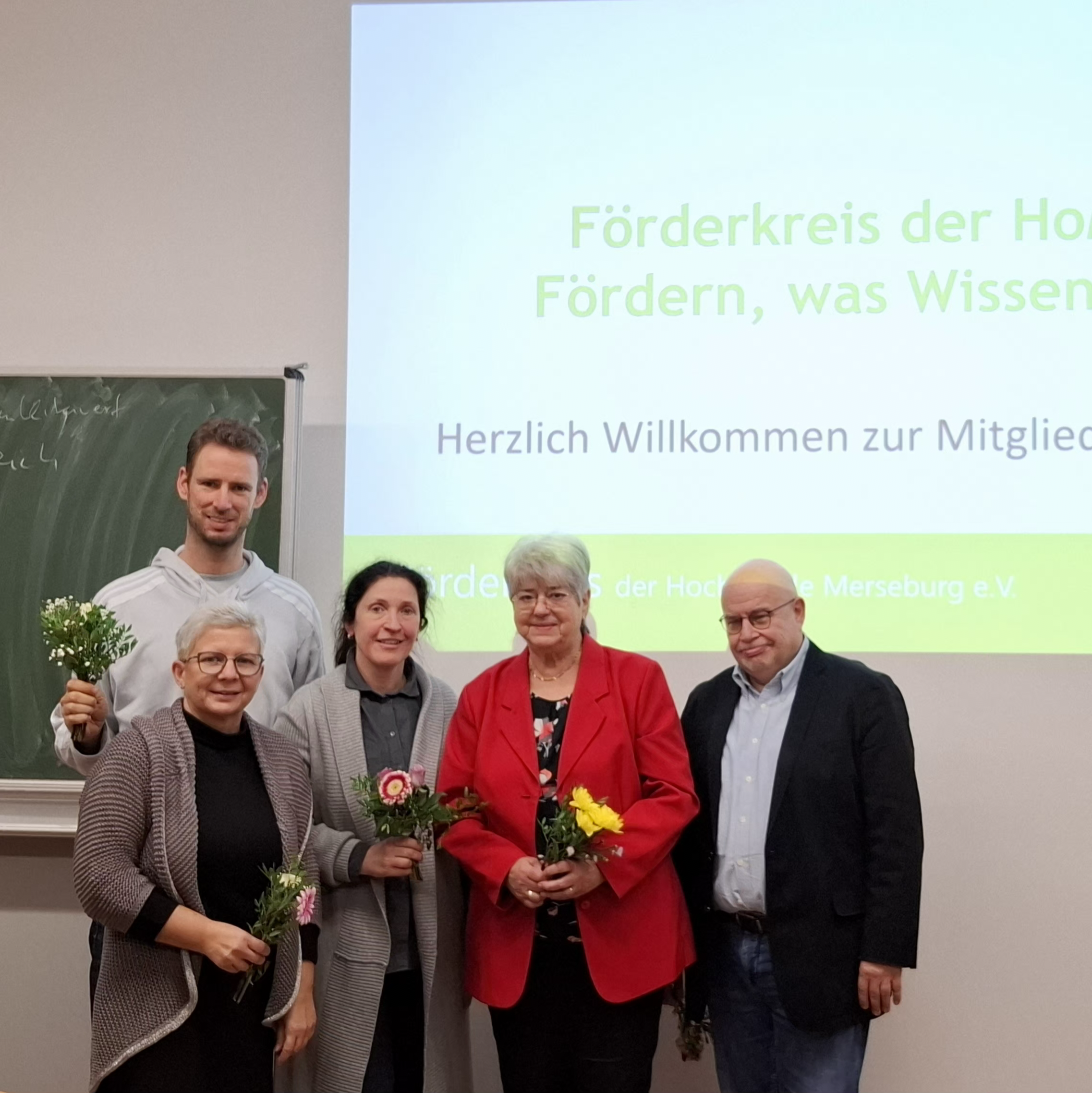 5 Personen klein, im Hintergrund Präsentation