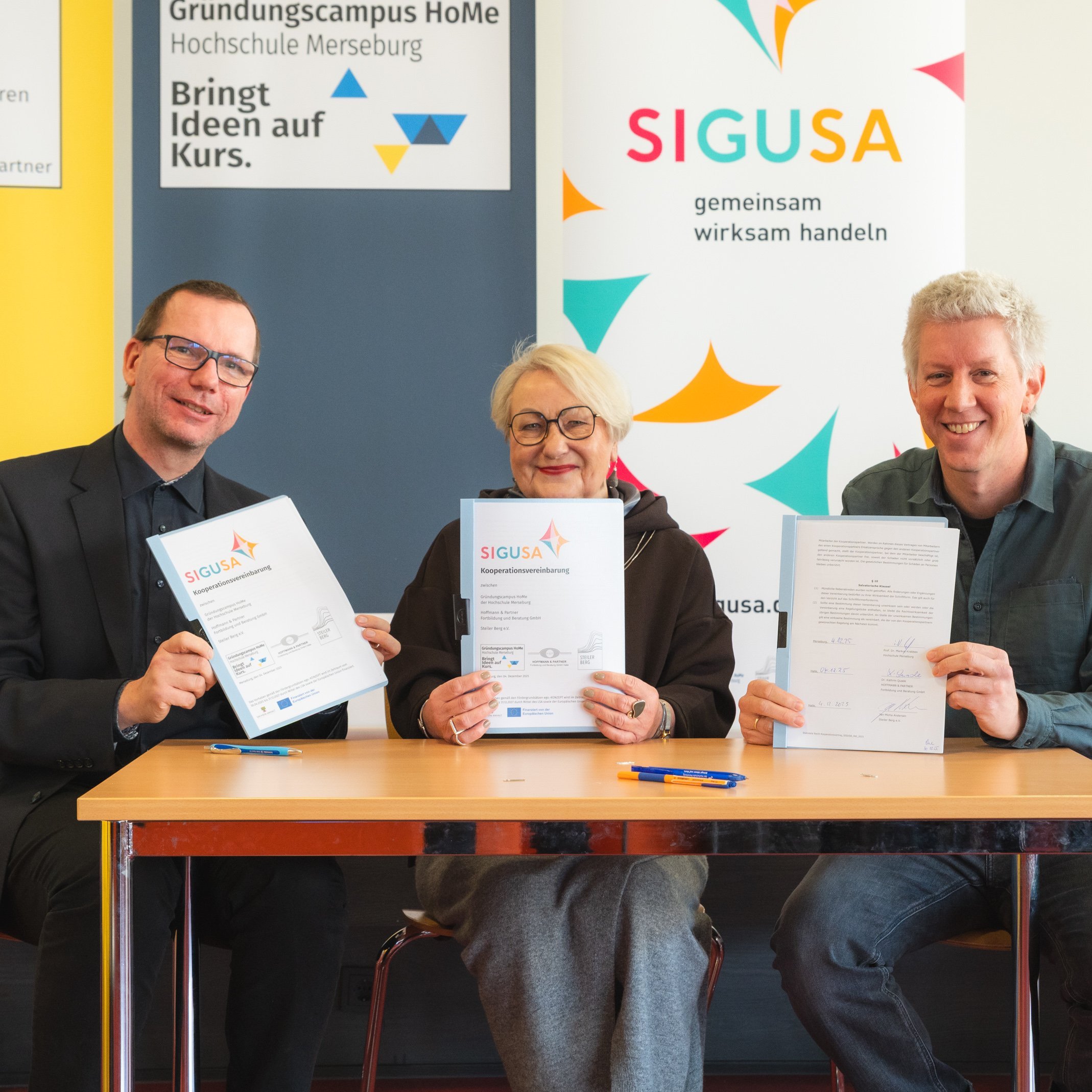 Neue Initiative SIGUSA gegründet Drei Personen sitzen an einem Tisch