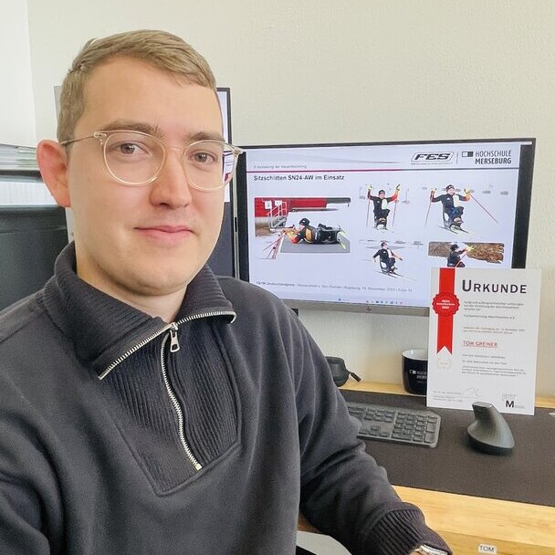 Eine Person sitzt am Schreibtisch vor seinem Monitor