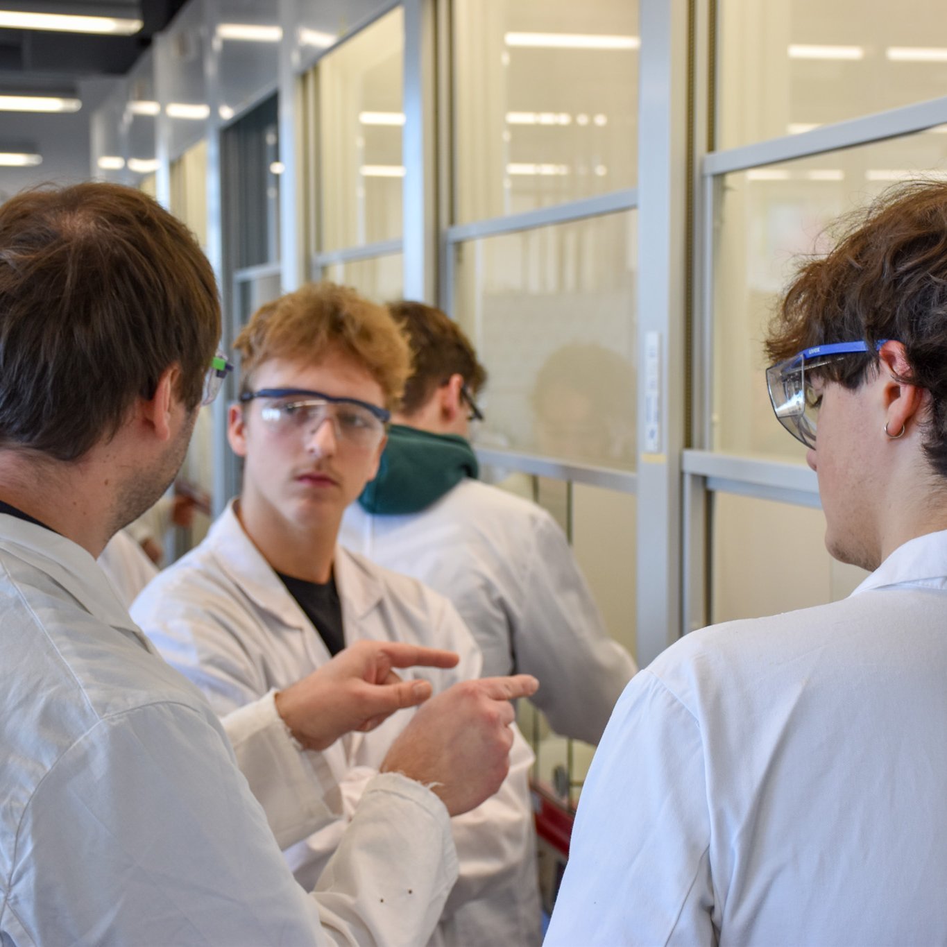 Lehrende gehen zusammen mit Schülern die Aufgabenstellung durch