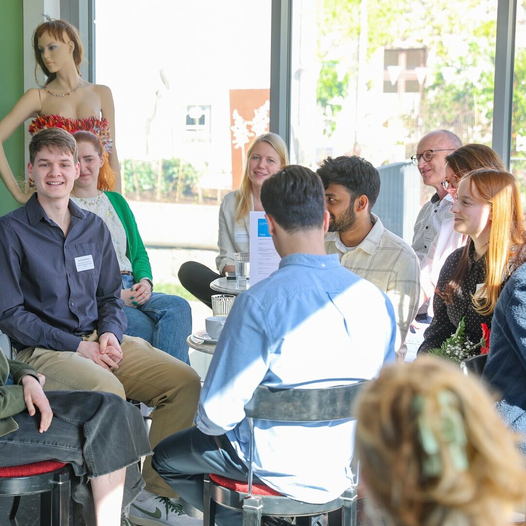 Personen sitzen zusammen und tauschen sich aus