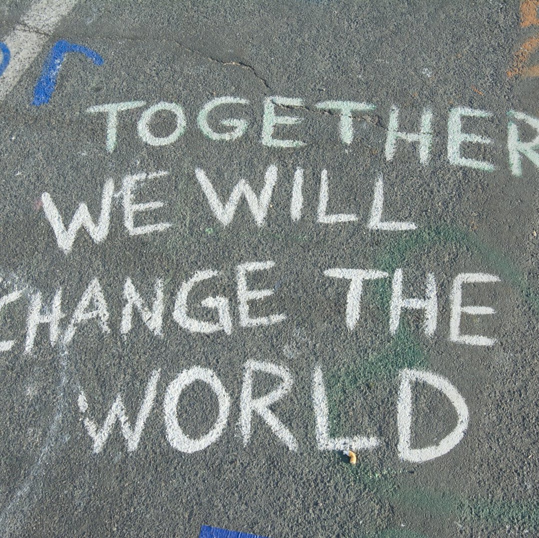 Schrift mit Kreide auf der Straße: together we will change the world