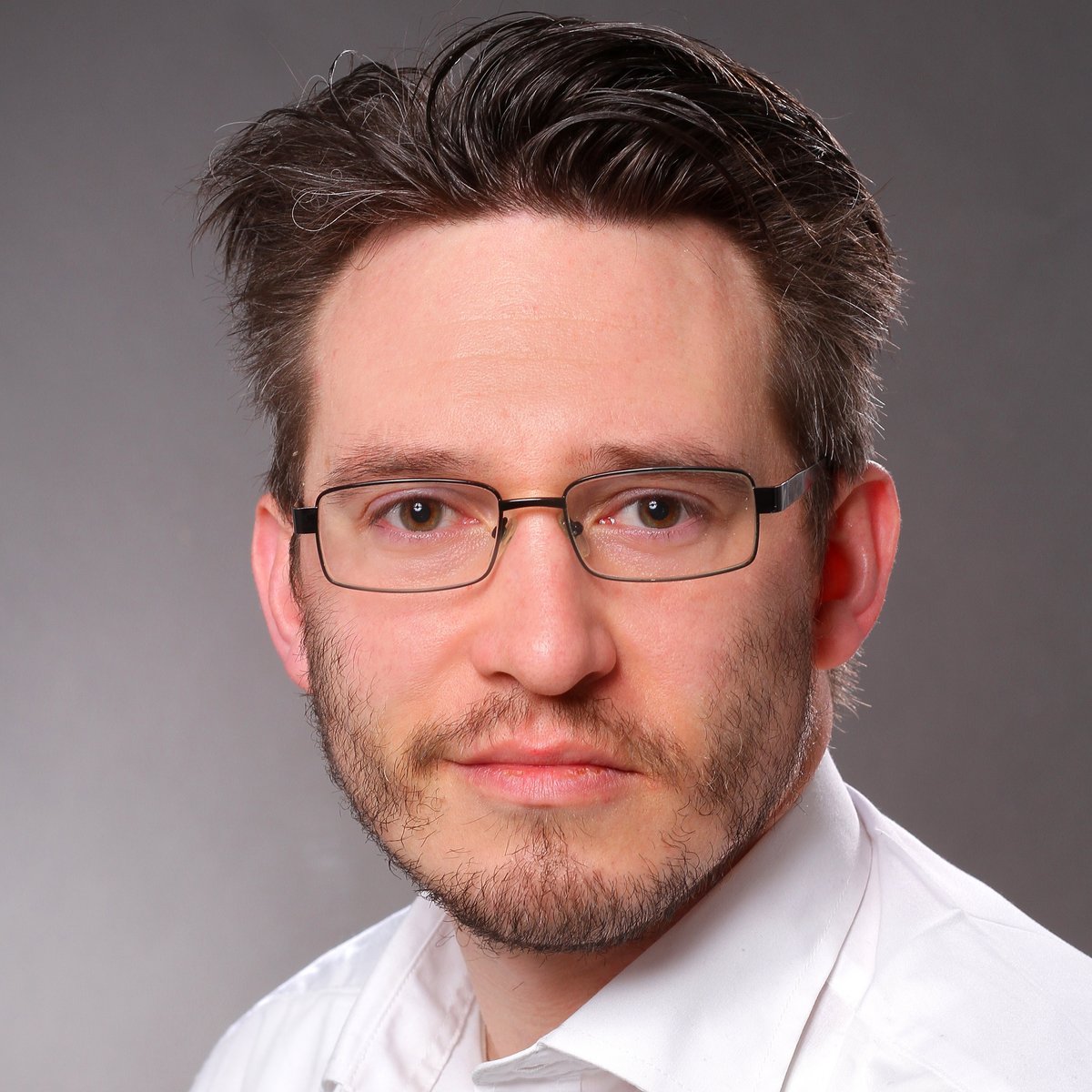 Das Porträt eines Mannes mit Brille in einem weißen Hemd