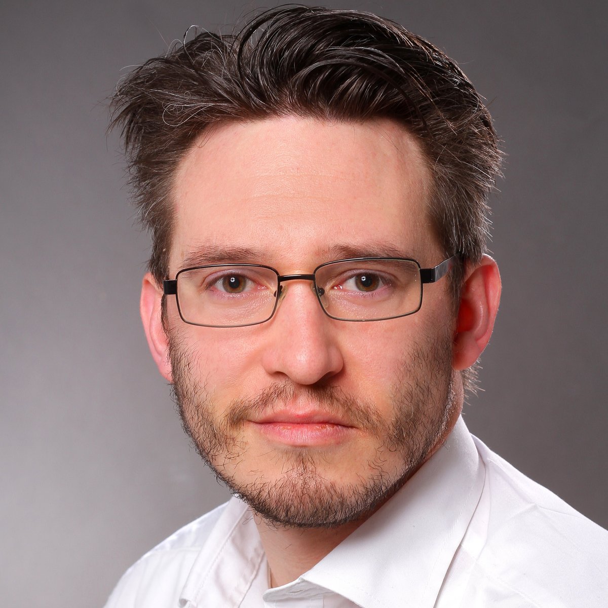 Das Porträt eines Mannes mit Brille in einem weißen Hemd