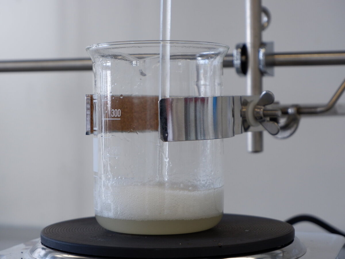 Becherglas mit einer schäumenden Flüssigkeit auf einer Heizplatte