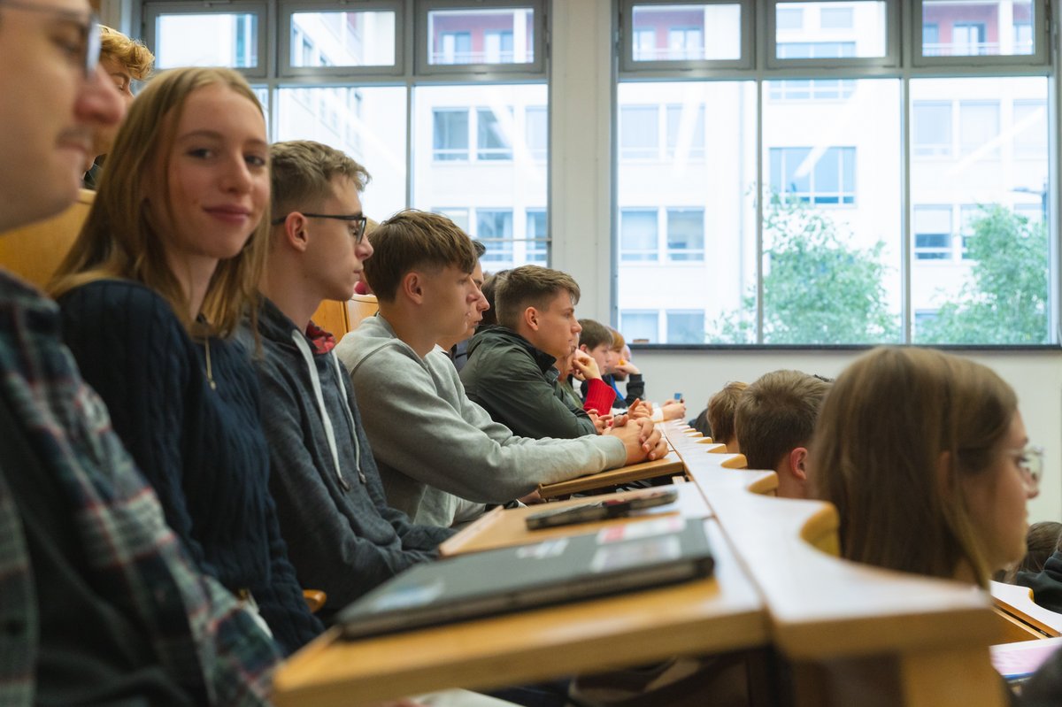 Viele Personen in einem Hörsaal Reihe, eine Person schaut in Kamera