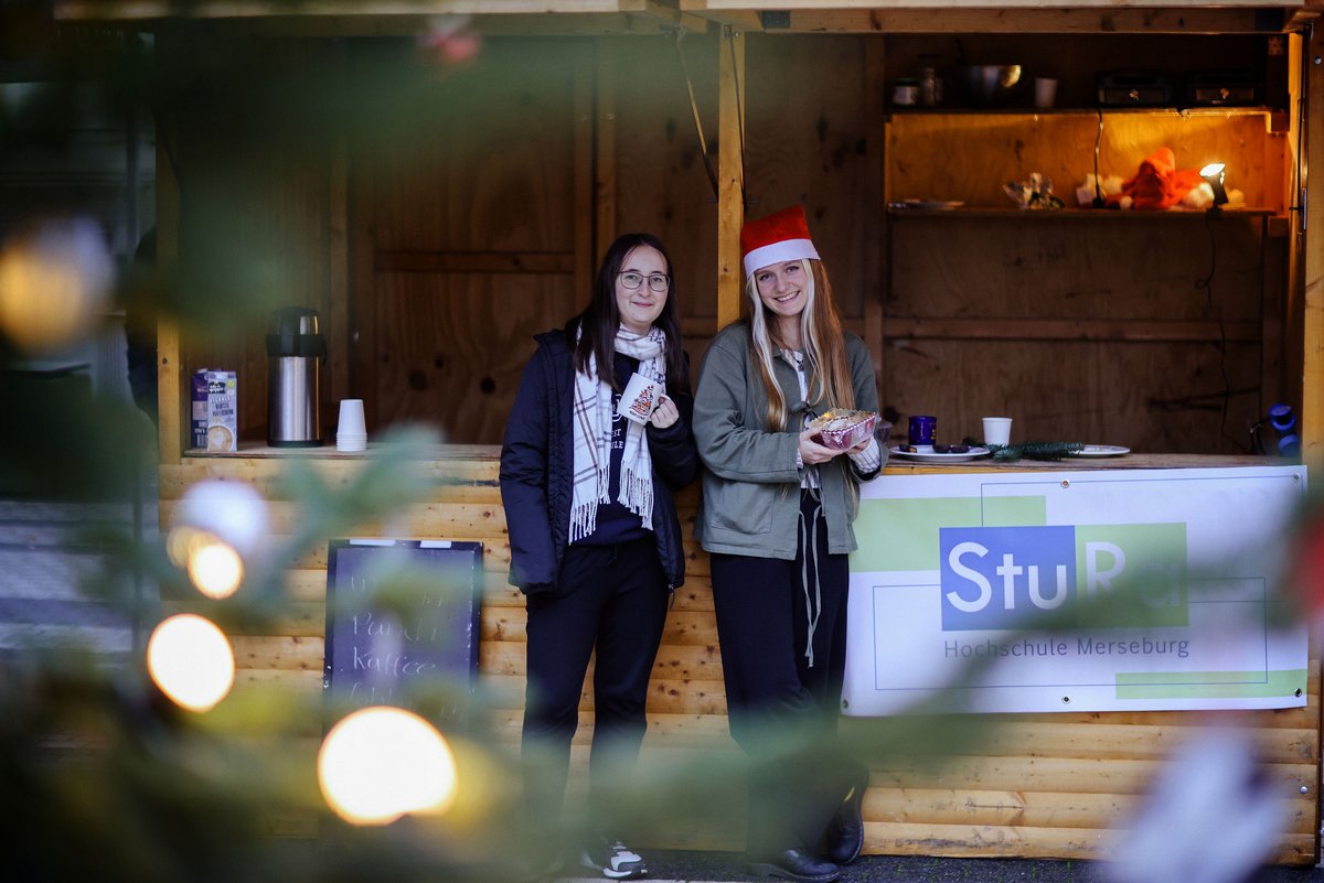 Campusweihnacht Bild 14 Zwei Personen vor einem Glühweinstand