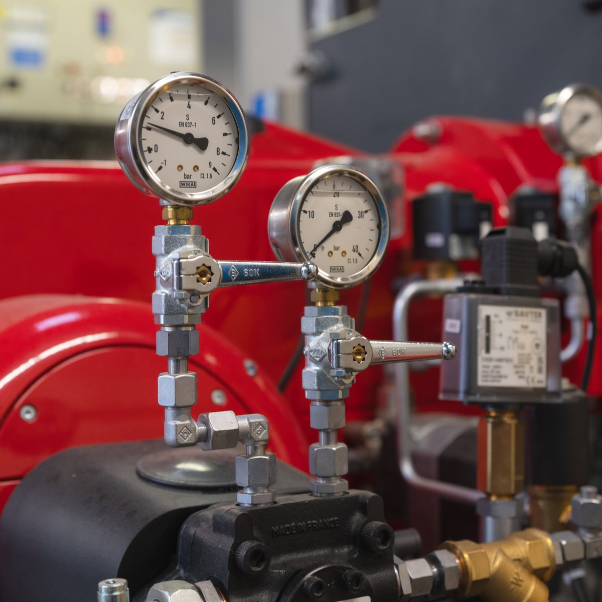 Eine Maschine die rot lackiert ist und verschiedene Messwerte anzeigt.