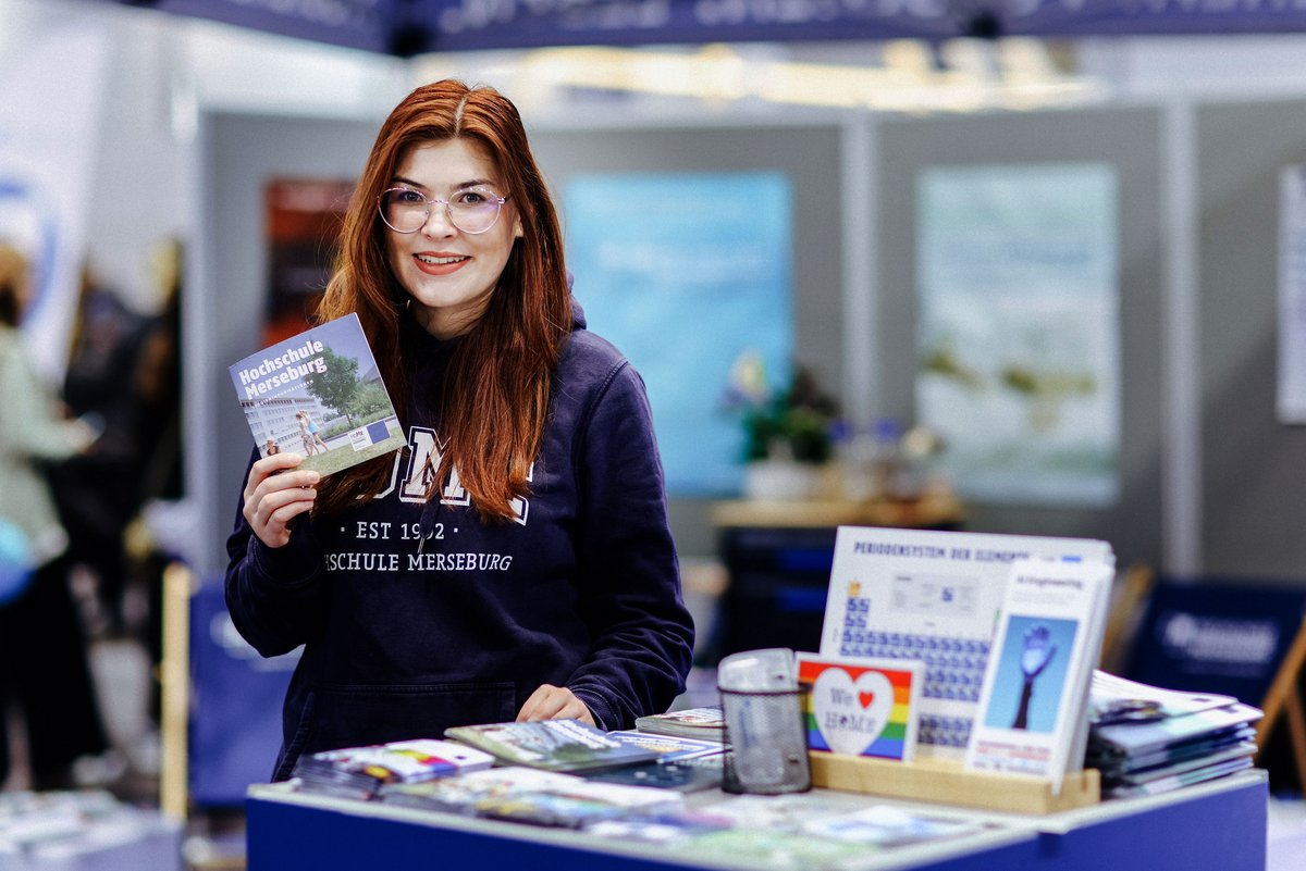 Eine Studentin steht vor einem Messestand